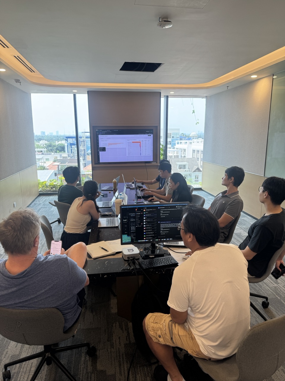 A founder team building at a table above the Saigon skyline